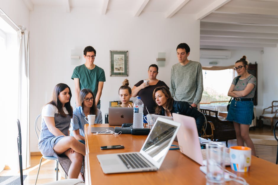 A group of people gathered around a laptop, representing the target audience for a blog